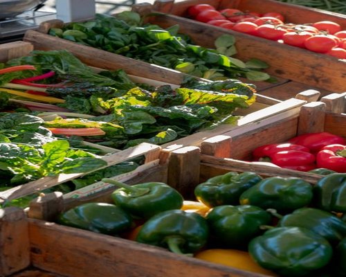 Fresh local market produce displayed in wooden crates