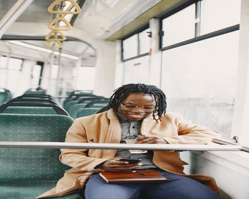 Commuter using a smartphone on a bus during golden hour